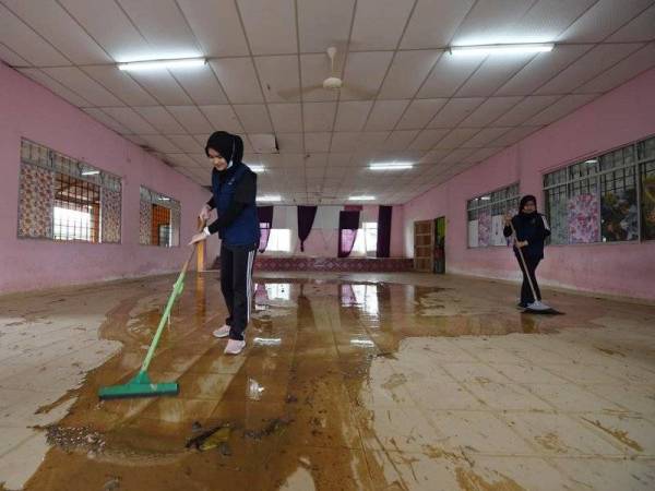 Antara warga UniSZA yang terlibat dalam Misi Bantuan Banjir UniSZA-KPT 2021 bagi membantu operasi pasca banjir di daerah Kemaman pada Selasa.