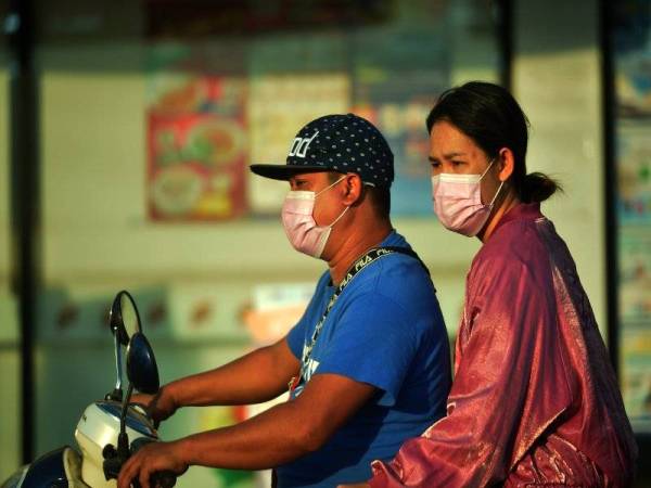 Orang ramai memakai pelitup muka ketika berada di kawasan terbuka di Bangkok, Thailand. Foto Xinhua