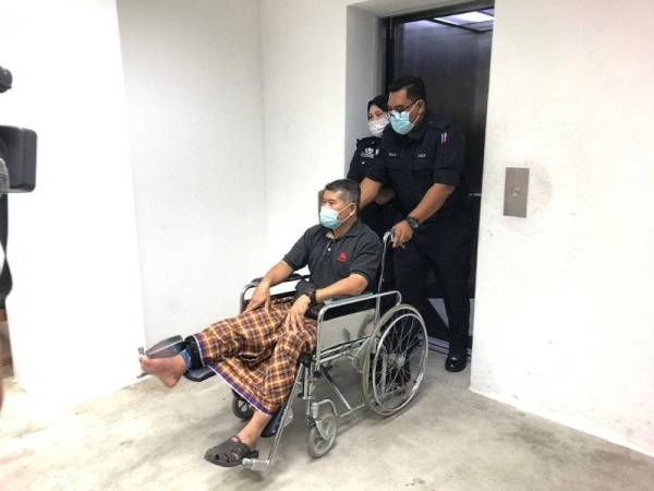 Yusri berkerusi roda dibantu polis keluar dari Mahkamah Majistret menggunakan lif ke lokap selepas dikenakan denda RM1,000.