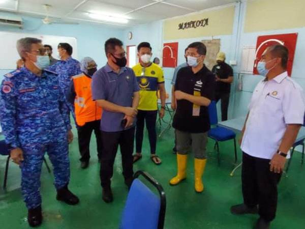 Azmin (tiga dari kiri) bertemu dengan komuniti Kampung Tembioh ketika program gotong-royong membersihkan balai raya yang terjejas banjir pada Ahad.