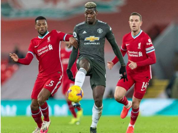 Pemain United, Paul Pogba (tengah) mengawal bola walaupun diasak dua pemain Liverpool pada perlawanan berkenaan.