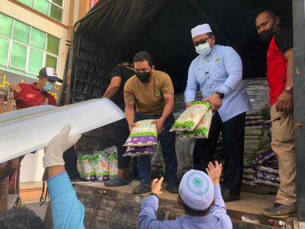 Ahmad Marzuk (dua, kanan) membantu mengangkat barangan bantuan Misi Bantuan Jabatan Agama Islam Wilayah Persekutuan (Jawi) Foodbank dan Masjid-Masjid di Wilayah Persekutuan ke Negeri Kelantan di Pengkalan Chepa pada Selasa.