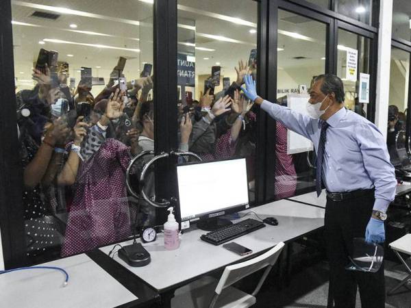 Muhyiddin meluangkan masa bertemu dengan para pesakit yang positif Covid-19 ketika mengadakan lawatan ke Hospital Bersepadu Taman Ekspo Pertanian Malaysia (MAEPS) 2.0 di Serdang pada Selasa.- Foto Bernama