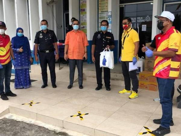 Mohd Shahrizal (tiga dari kanan) menyerahkan bekalan makanan kepada petugas barisan hadapan di Balai Polis Tanjong Karang di sini pada Rabu.