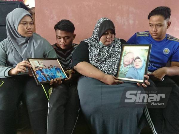 Novi Margareta (dua dari kanan) bersama tiga adiknya melihat gambar ibu bapa mereka ketika menerima kehadiran Pegawai Perhubungan UMNO Melaka, Datuk Mohd Yusof Abu Hassan di rumah sewa mereka Kampung Pulau Gadong pada Khamis.