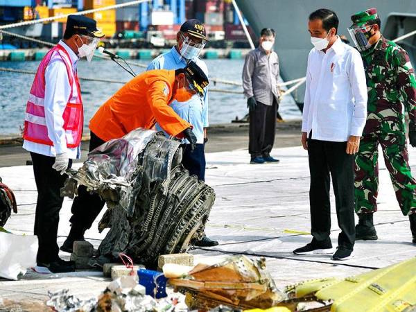 Presiden Joko Widodo atau Jokowi turut melawat pelabuhan di Jakarta yang menjadi lokasi pengumpulan cebisan tubuh mangsa penumpang dan serpihan pesawat SJ182. - Foto: AFP