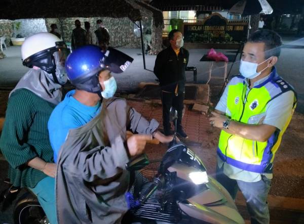 Adzli membuat pemeriksaan ke atas penunggang motosikal yang melalui sekatan jalan raya di Jalan Bedong-Sungai Petani, tengah malam tadi sejurus Perintah Kawalan Pergerakan dilaksanakan hari pertama di Kedah.