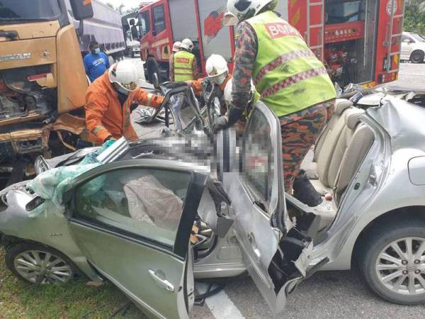 Anggota bomba menjalankan operasi mengeluarkan mayat mangsa yang tersepit dalam nahas di Tapah pada Jumaat. Foto: Ihsan PDRM