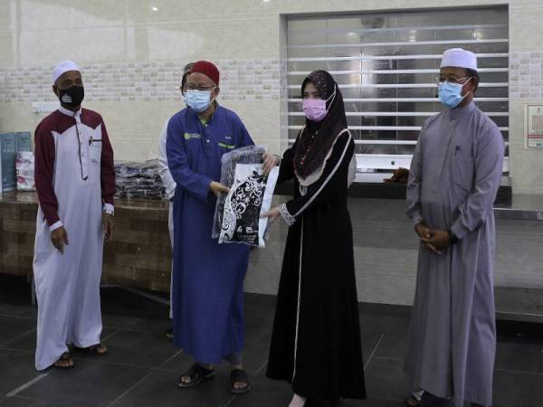 Zulkifli (dua, kiri) menyampaikan bantuan persekolahan kepada wakil penerima di Masjid Taman Bandar Senawang, hari ini. - Foto Bernama