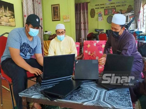 Syeikh Kyairder Syamzarey (kanan) memberikan penerangan kepada pelanggan yang mahu mendapatkan komputer terpakai dijualnya di Kampung Rasal, Tok Uban, Pasir Mas.