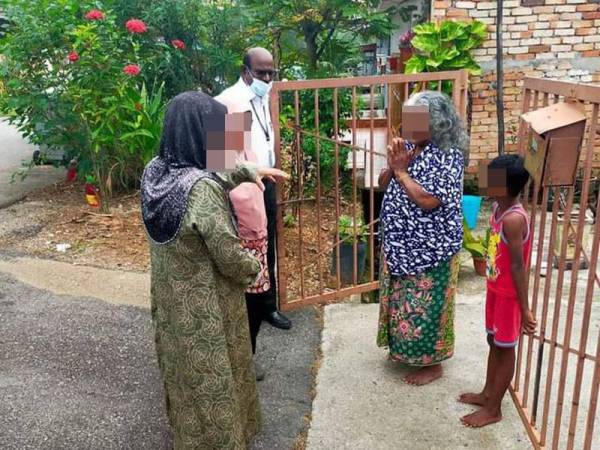 Gunasekaran (tengah) semasa bertemu Thanaletchumy dan jirannya yang melecur akibat terkena mercun pada Sabtu.