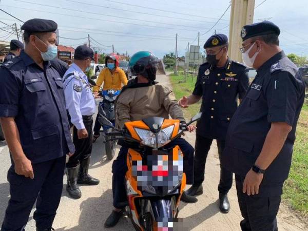 Ketua Polis Kelantan, Datuk Shafien Mamat (kanan) dan Hanif (dua dari kanan) memeriksa pengguna jalan raya di sekatan jalan raya (SJR) Tunjong pada Selasa.