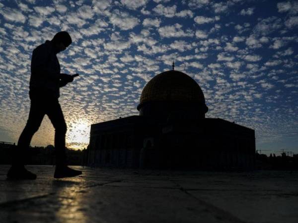 Seorang lelaki melintasi bahagian luar Masjid Qubbat al-Sakrah (Dome of the Rock). - AFP