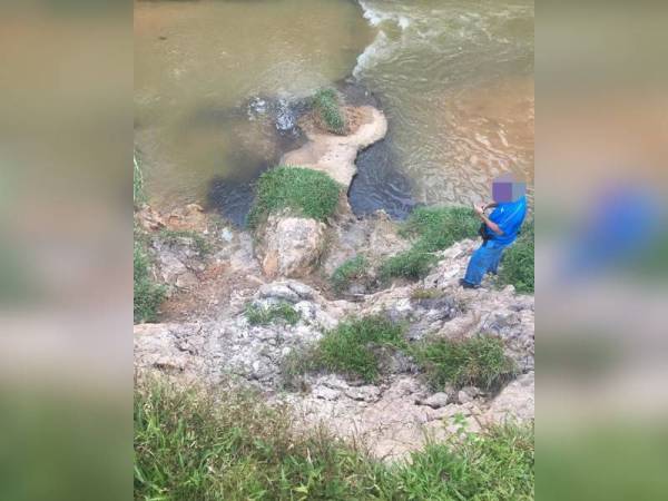 Seorang anggota JAS melakukan pemantauan keadaan Sungai Melantai selepas dicemari efluen hingga mengakibatkan airnya menjadi keruh di Kampung Bentong, Kluang pada Selasa.