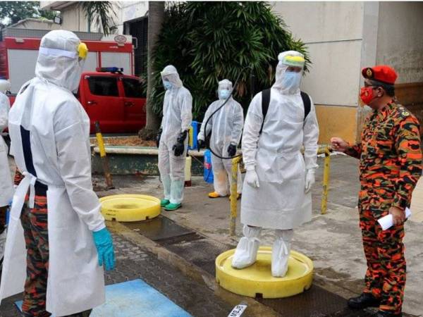 Yahaya (kanan) meninjau persiapan anggotanya sebelum melakukan proses sanitasi di kawasan Pasar Borong Pandan City di Jalan Tebrau, Johor Bahru, pada Rabu.