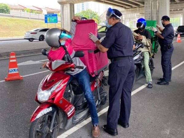 Pemeriksaan di sekatan jalan raya bagi mengekang kegiatan pengedaran dadah yang menggunakan khidmat penghantar makanan. - Foto: FB Jabatan Siasatan Jenayah Narkotik PDRM