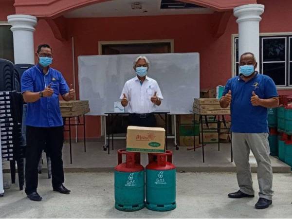 Sazli (tengah) menyerahkan sumbangan kepada Ketua Kampung Laut, Mohd Ridzal Mohd Hamdan (kanan) untuk diagihkan kepada mangsa banjir di kampung berkenaan. Turut kelihatan Hairul Hamid.