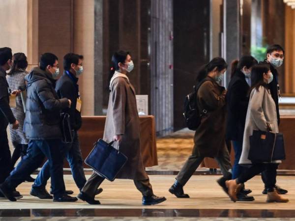 Pegawai Beijing tiba di Hilton Wuhan Optics Valley Hotel untuk menyertai mesyuarat bersama pakar WHO pada Jumaat. - Foto: AFP