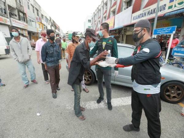 Dr Asmadi mengagihkan makanan percuma kepada golongan sekitar bandar Kuantan, Pahang pada Ahad.