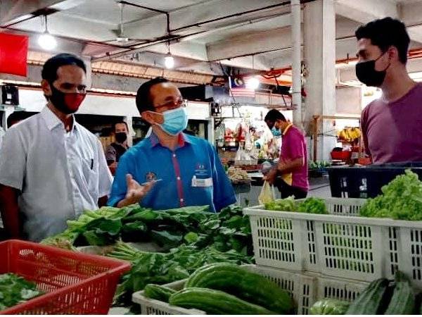 Azman (tengah) ketika meninjau jualan sayur di Pasar Besar Alor Setar pada Khamis.