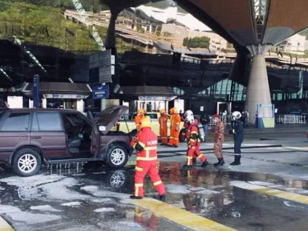 Anggota bomba memadam kebakaran yang melibatkan sebuah kereta di Lapangan Terbang Antarabangsa Kuala Lumpur (KLIA), Sepang pada Jumaat.