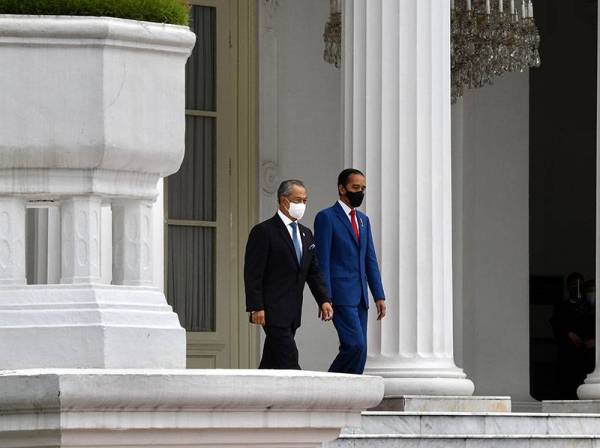 Muhyiddin (kiri) disambut oleh Presiden Indonesia Joko Widodo sebelum diberikan sambutan negara di Istana Merdeka hari ini sempena lawatan rasmi dua hari ke Indonesia. -Foto Bernama