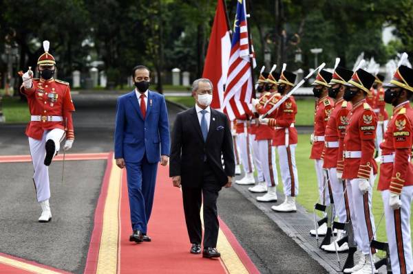 Muhyiddin diiringi Joko Widodo (dua, kiri) memeriksa barisan kawalan kehormat oleh Pasukan Keselamatan Presiden Indonesia pada sambutan negara di Istana Merdeka hari ini sempena lawatan rasmi dua hari ke Indonesia. -Foto Bernama