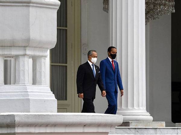 Muhyiddin (kiri) disambut oleh Presiden Indonesia Joko Widodo sebelum diberikan sambutan negara di Istana Merdeka hari ini sempena lawatan rasmi dua hari ke Indonesia. -Foto Bernama