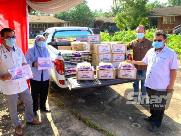 Che Abdullah (kanan) menunjukkan bantuan di bawah misi MAFI Prihatin Kelantan yang akan diagihkan kepada petani di Tanah Merah.