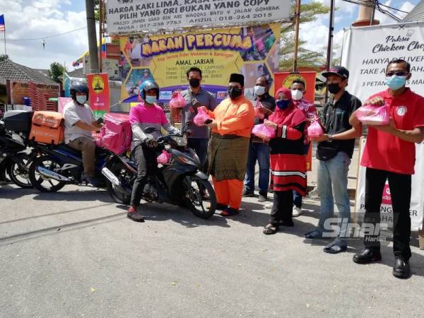 Penganjur mengagihkan bungkusan makanan kepada penghantar makanan dan barangan di pekaramgan Masjid Jamek Saad Bin Abi Waqqas