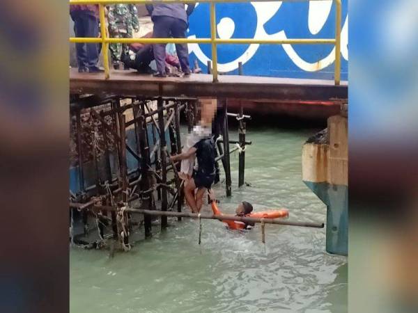 Mangsa (berseluar putih) berjaya diselamatkan dan di bawa naik ke darat. - Agensi