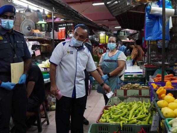 Adnan (tengah) turun padang meninjau harga sayuran di Pasar Besar Siti Khadijah di Kota Bharu pada Selasa.