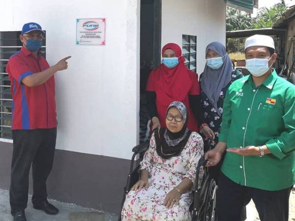 Noh (kiri) bergambar bersama Hamidah (dua dari kanan) pada Majlis Penyerahan Program Bina Rumah Baharu PUNB di Parlimen Tanjong Karang pada Selasa.