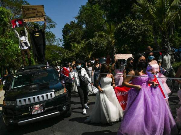 Beberapa penunjuk perasaan wanita memakai gaun seperti 'puteri' ketika menyertai demonstrasi di Yangon. - Foto: AFP