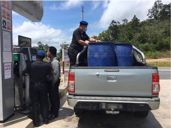 Pasukan KPDNHEP Dungun memeriksa kenderaan dan tong drum yang digunakan untuk mengisi diesel di sebuah stesen minyak di Dungun, Terengganu. - Foto KPDNHEP.