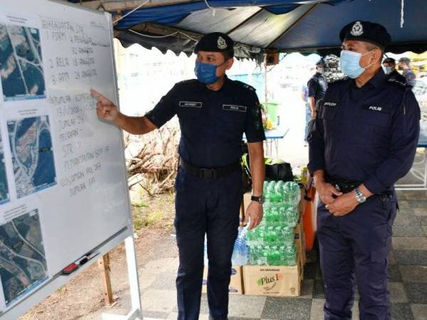 Timbalan Pengarah Narkotik (Risikan/Operasi) Jabatan Siasatan Jenayah Narkotik Bukit Aman DCP Zainudin Ahmad (kanan) mendengar penerangan daripada Ketua Polis Daerah Muallim Supt Sulizmie Affendy Sulaiman (kiri) mengenai pelan operasi Sekatan Jalan Raya (SJR) ketika mengadakan lawatan SJR di Stesen Bas Tanjung Malim hari ini. - Foto Bernama