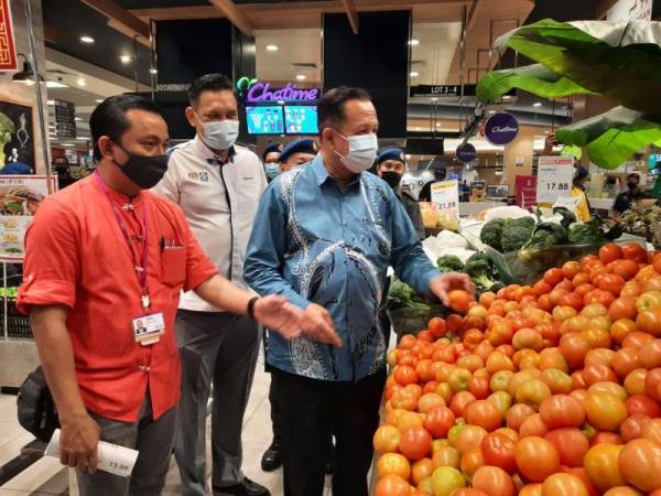 Mohd Ridzuan (tengah) mengiringi Abdul Halim meninjau harga barangan kawalan di Pasaraya AEON di Queensbay pada Khamis.