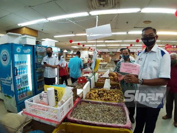 Rosol (kanan) meninjau pematuhan Skim Harga Maksimum Musim Perayaan (SHMMP) Tahun Baru Cina 2021 di sebuah pasar raya di Kuala Terengganu pada Khamis.