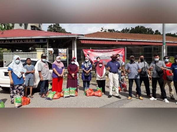 Che Zakaria (tengah) dan Mohd Salim selepas menyampaikan bantuan kepada penduduk kategori B40 di pekarangan Surau Al Asyariah, Flat Balau, Taman Rinting, Pasir Gudang, pada Sabtu.