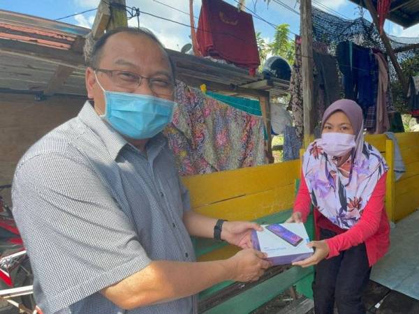 Amzad menyerahkan tablet kepada salah seorang pelajar di Parlimen Kuala Terengganu. (Foto: Ihsan Amzad)