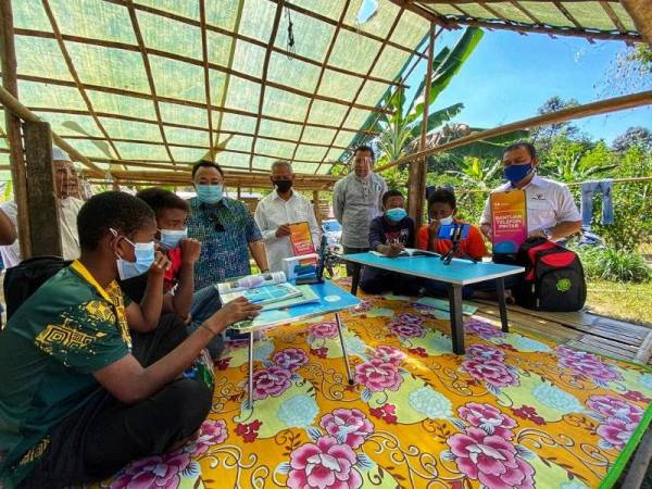 Ammar (tiga dari kiri) melihat anak-anak orang asli suku Kensiu mengikuti sesi PdPR di sebuah pondok di Kampung Lubuk Legong, Baling pada Ahad.