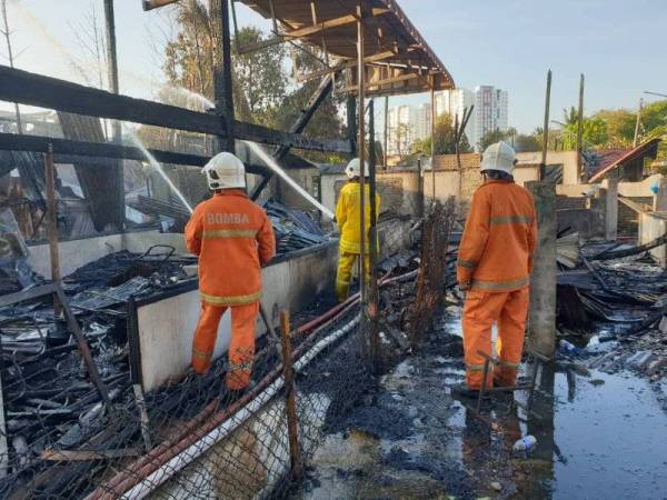 Beberapa anggota bomba bertungkus-lumus memadamkan kebakaran rumah di Jalan Seberang Kereta Api, Sungai Korok, Alor Setar pada Ahad.