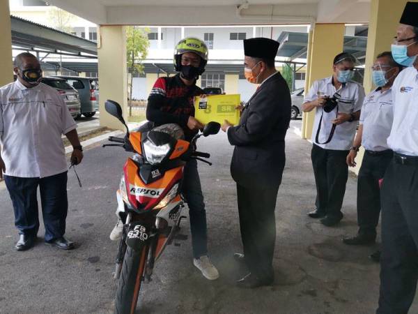 Md Fiah menyerahkan surat penempatan kepada guru, Al-Ikhlas Isahak.