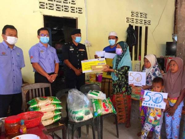 Che Som dan cucu-cucunya terharu menerima kunjungan dan sumbangan daripada Suzaimi (tiga, dari kiri) dan Mohd Azran (dua, dari kiri) di rumah mereka di Kampung Cabang Tiga Gemas, Jalan Sungai Sam-Dabong, Kuala Krai.