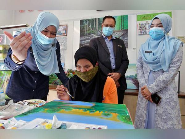 Rina Mohd Harun (kiri) menyantuni pelatih, Siti Hartini Darwis, 22, ketika membuat lawatan ke Taman Sinar Harapan (TSH) Ziyad Zolkefli, Cheras hari ini. - Foto Bernama