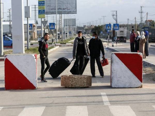 Gambar fail menunjukkan beberapa orang lelaki Palestin membawa beg di Lintasan Rafah untuk mengembara dari Genting Gaza ke Mesir baru-baru ini. - Foto AFP