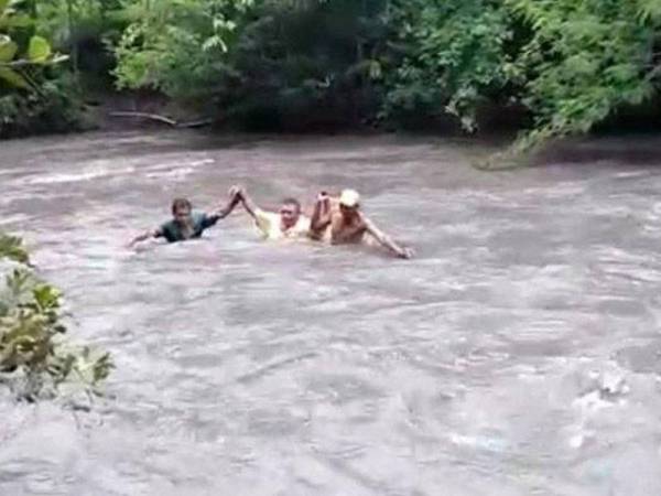 Guru sanggup mengadai nyawa seberangi arus sungai untuk menghantar tugasan kepada pelajar ketika pandemik Covid-19. - Foto Kompas