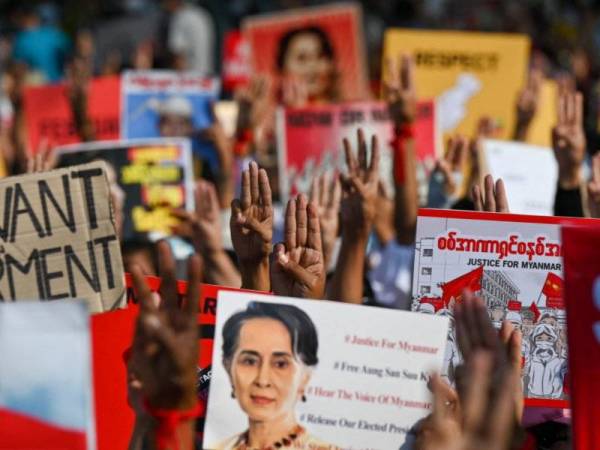 Kumpulan antirampasan kuasa menunjukkan simbol hormat tiga jari ketika melaungkan slogan menggesa pembebasan Suu Kyi di Yangon pada Selasa. - Foto: AFP