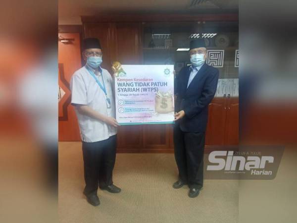 Abdul Aziz (kanan) menyerahan poster Kempen Penyaluran Wang Tidak Patuh Syariah ke Baitumal kepada Setiausaha MAIS, Dr Ahmad Shahir Makhtar sebagai simbolik pelancaran kempen.