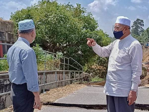 Ahmad (kanan) Azami turun padang meninjau kesan runtuhan tebing Sungai Kelantan di Kampung Pohon Chelagi, Pasir Mas pada Rabu.